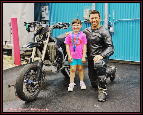 A young Photowalk participant poses with a stunt driver backstage at the Lights, Motors, Action Extreme Stunt Show in Disney's Hollywood Studios, Walt Disney World, Orlando, Florida.