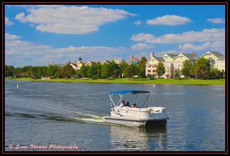 A guest pilots a pontoon rental boat past the Saratoga Springs Resort, Walt Disney World, Orlando, Florida.