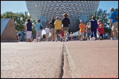 A low view of people walking towards Spaceship Earth in Epcot, Walt Disney World, Orlando, Florida