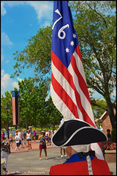A Spirit of America Fife and Drum Corps member carries the Spirit of '76 flag in front of the American Adventure in Epcot's World Showcase, Walt Disney World, Orlando, Florida