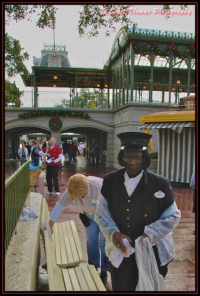 Cast Members drying off benches in the Magic Kingdom, Walt Disney World, Orlando, Florida