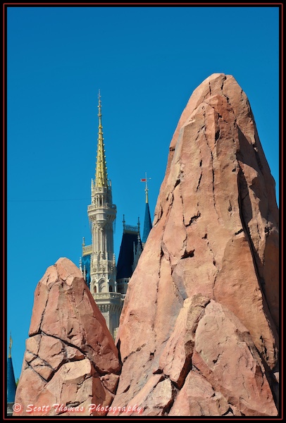 Spires of Cinderella Castle behind rock outcroppings in Tomorrowland at the Magic Kingdom., Walt Disney World, Orlando, Florida