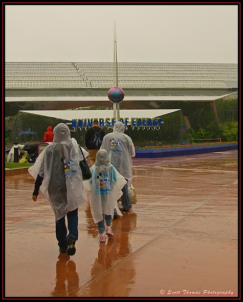 People in Disney ponchos walking in the rain at Epcot, Walt Disney World, Orlando, Florida