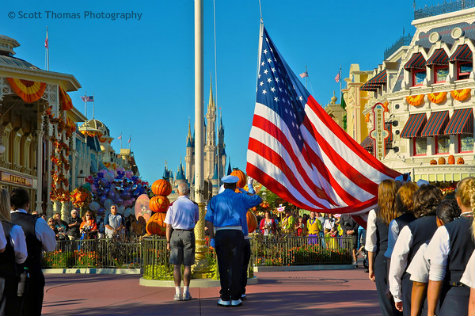 Veteran of the Day and Disney Security pay homage as the flag is lowered during the Flag Retreat ceremony in the Magic Kingdom, Walt Disney World, Orlando, Florida.