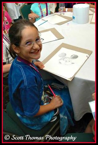 Samantha Hogan proudly shows off her Mickey Mouse drawing she made under the instruction of Johnny Zotto at MagicMeets on Saturday, July 19, in Harrisburg, PA.