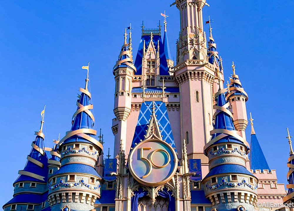 https://allears.net/wp-content/uploads/2021/11/2021-wdw-disney-world-atmosphere-magic-kingdom-cinderella-castle-50th-anniversary-sign.jpg