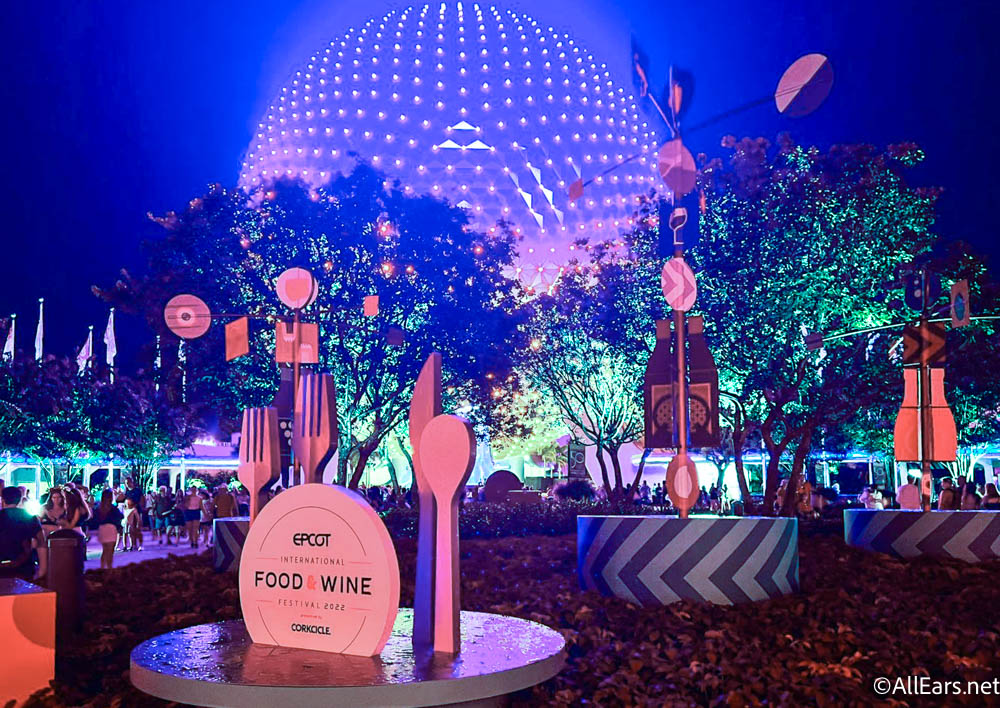 https://allears.net/wp-content/uploads/2022/07/2022-wdw-epcot-atmo-night-dark-food-and-wine-festival-sign-decor-spaceship-earth-lights.jpg